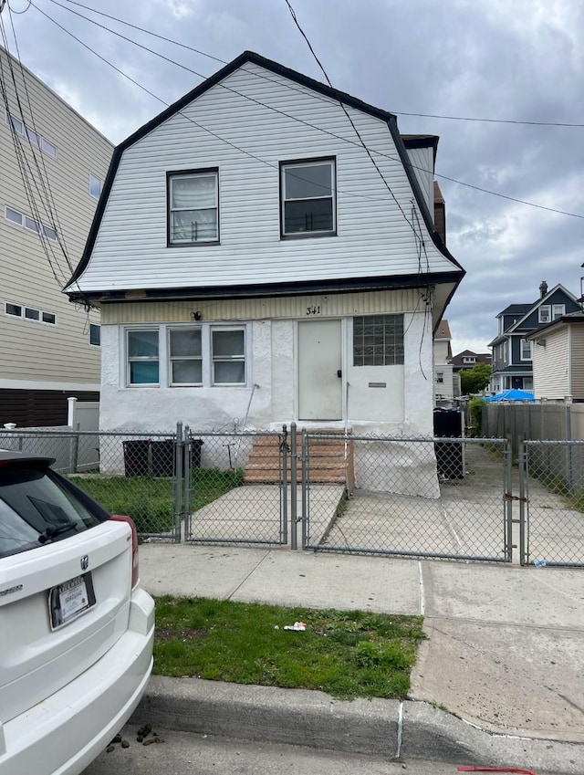 341 Bch 67th St, Far Rockaway, NY 11692 - colonial inspired home with a gambrel roof, a gate, and a fenced front yard