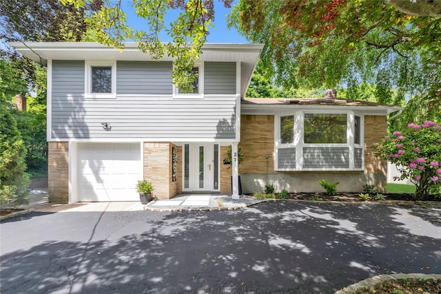 27 Meadowfield Ln, Glen Cove, NY 11542 - tri-level home featuring brick siding, an attached garage, and a chimney