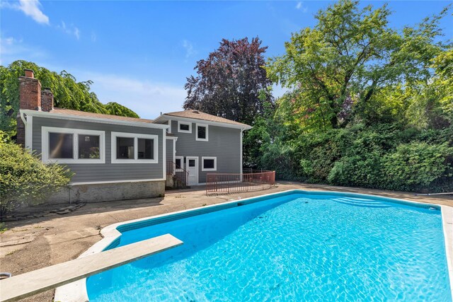 27 Meadowfield Ln, Glen Cove, NY 11542 - swimming pool featuring a diving board, a wooden deck, and a patio area