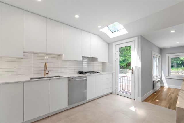 27 Meadowfield Ln, Glen Cove, NY 11542 - kitchen featuring a sink, appliances with stainless steel finishes, a skylight, white cabinets, and light countertops