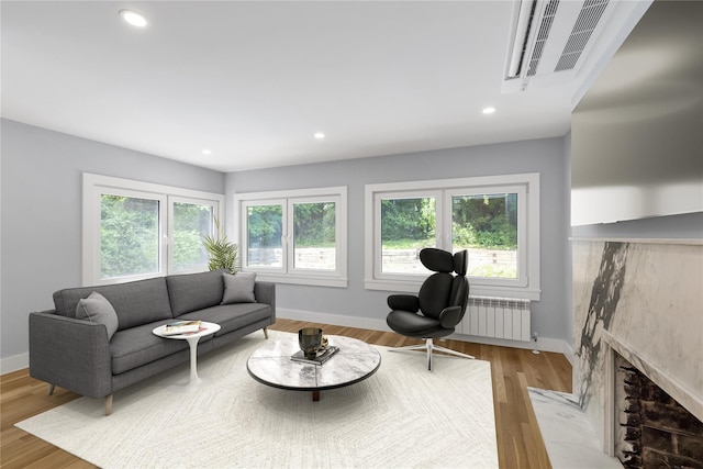 27 Meadowfield Ln, Glen Cove, NY 11542 - living room featuring radiator heating unit, baseboards, a fireplace, and recessed lighting