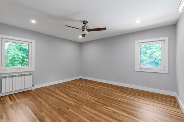 27 Meadowfield Ln, Glen Cove, NY 11542 - unfurnished room featuring radiator, plenty of natural light, light wood-style floors, ceiling fan, and recessed lighting