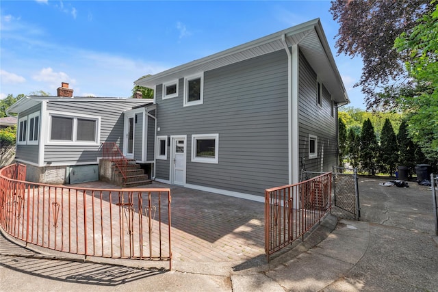 27 Meadowfield Ln, Glen Cove, NY 11542 - back of house with a chimney, a gate, and a patio