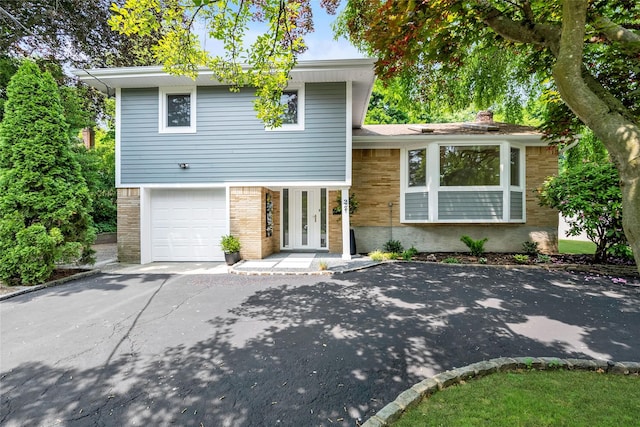 27 Meadowfield Ln, Glen Cove, NY 11542 - tri-level home with asphalt driveway, brick siding, a garage, a chimney, and french doors