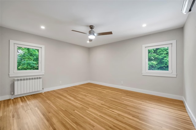 27 Meadowfield Ln, Glen Cove, NY 11542 - empty room with radiator heating unit, a wall mounted AC, light wood-style floors, a ceiling fan, and recessed lighting