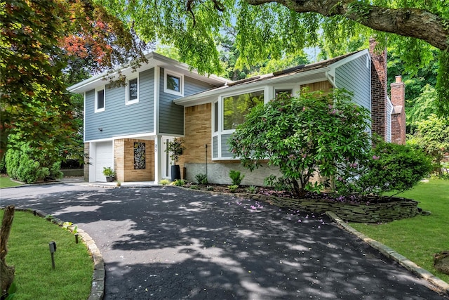 27 Meadowfield Ln, Glen Cove, NY 11542 - tri-level home featuring asphalt driveway and an attached garage