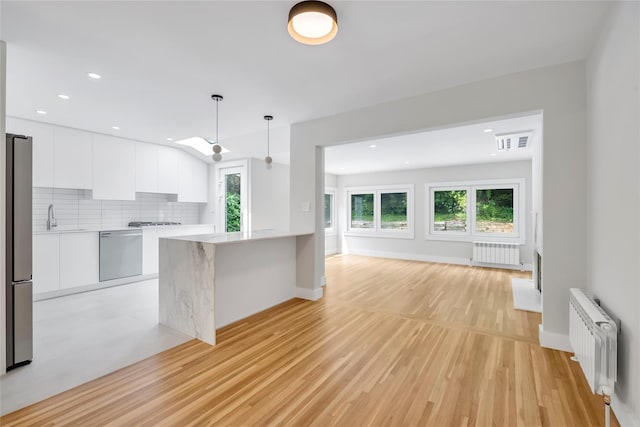 27 Meadowfield Ln, Glen Cove, NY 11542 - kitchen featuring radiator heating unit, modern cabinets, stainless steel appliances, and recessed lighting