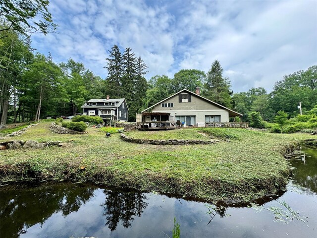 210A Seven Bridges Rd, Mount Kisco, NY 10549 - back of property featuring a detached garage, a deck with water view, and a lawn