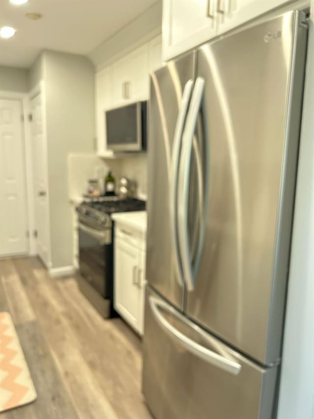 38 Tulip Ct, Nanuet, NY 10954 - kitchen featuring stainless steel appliances, white cabinetry, light wood-style flooring, and recessed lighting