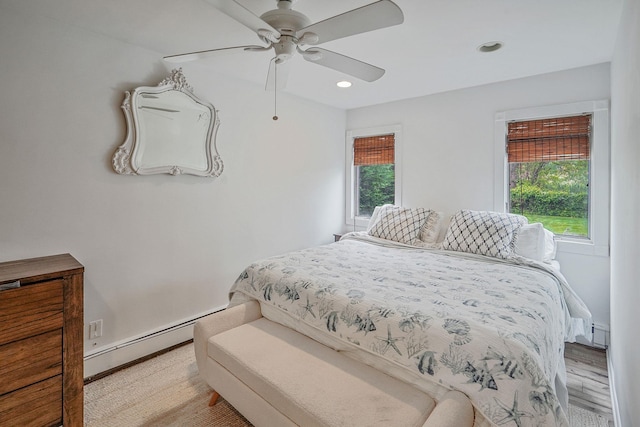 215 Lyman Rd, East Patchogue, NY 11772 - bedroom featuring baseboard heating, recessed lighting, a ceiling fan, and wood finished floors