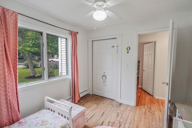 215 Lyman Rd, East Patchogue, NY 11772 - bedroom featuring light wood finished floors and a baseboard heating unit