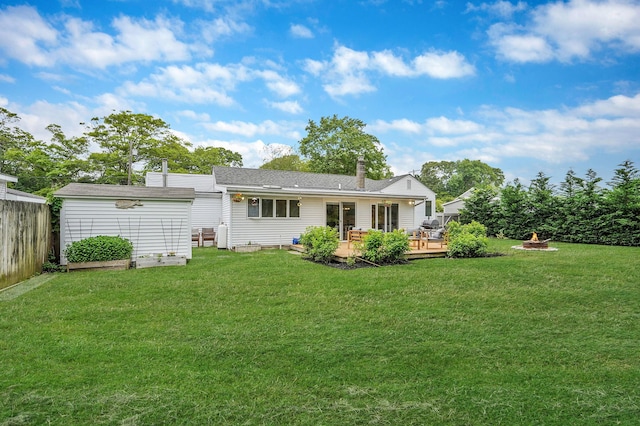 215 Lyman Rd, East Patchogue, NY 11772 - rear view of property featuring an outdoor fire pit, a wooden deck, a chimney, and roof with shingles