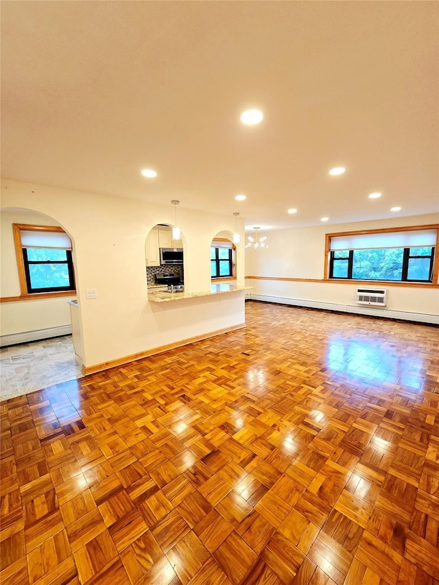 505 Central Ave Unit 211, White Plains, NY 10606 - unfurnished living room with a baseboard heating unit, recessed lighting, a chandelier, an AC wall unit, and baseboards
