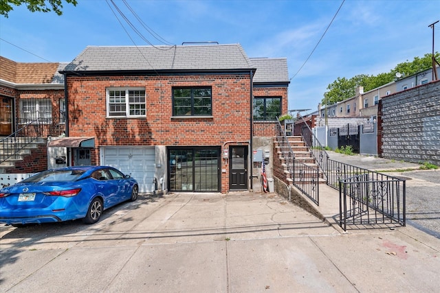 209 Onderdonk Ave, Ridgewood, NY 11385 - view of front of property featuring driveway, brick siding, stairway, and a garage
