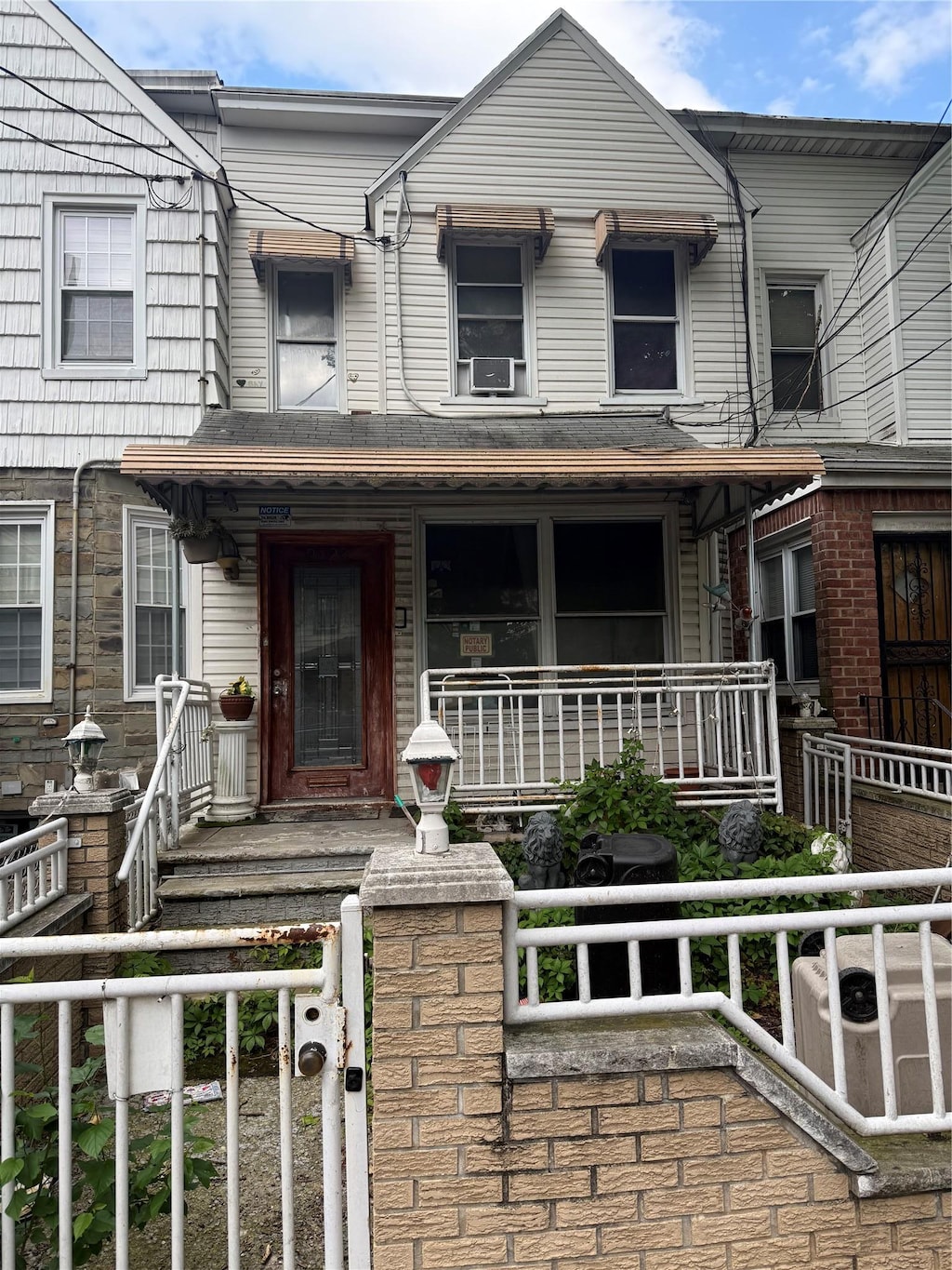 9423 115th St, Richmond Hill, NY 11419 - view of property with a porch, a fenced front yard, cooling unit, and a gate