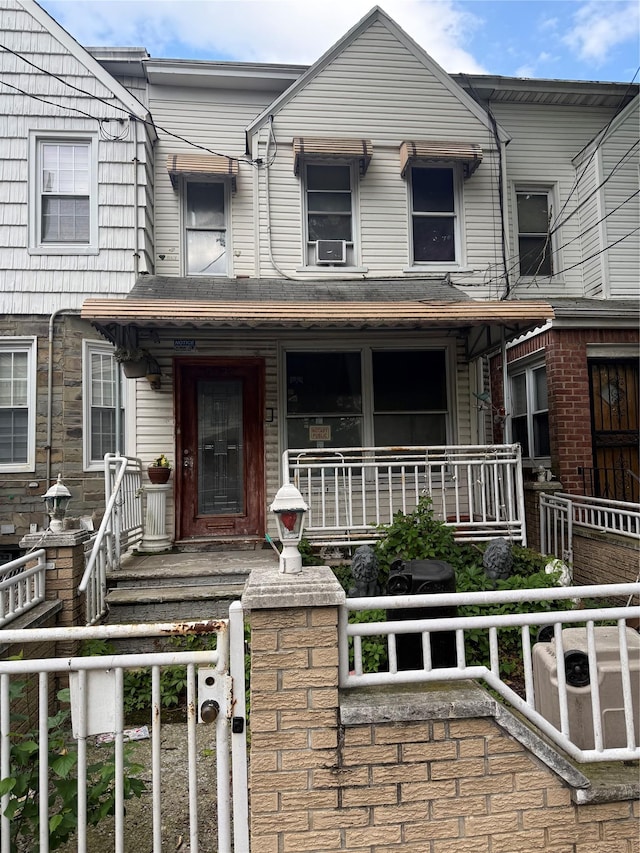 9423 115th St, Richmond Hill, NY 11419 - view of property with a porch, a fenced front yard, cooling unit, and a gate