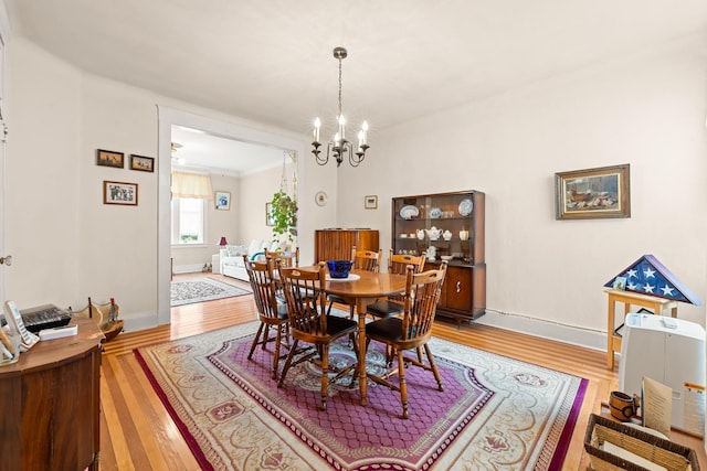33-21 82nd St Unit 51, Jackson Heights, NY 11372 - dining room featuring light wood-style flooring, a chandelier, and baseboards