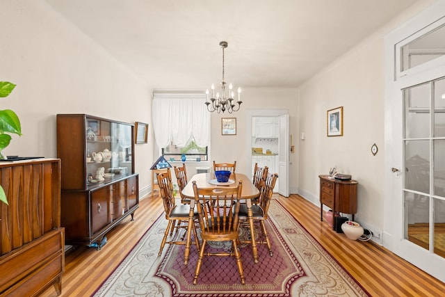 33-21 82nd St Unit 51, Jackson Heights, NY 11372 - dining area featuring a chandelier, light wood-style flooring, and baseboards