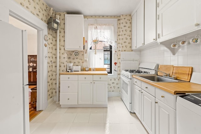 33-21 82nd St Unit 51, Jackson Heights, NY 11372 - kitchen featuring white appliances, wallpapered walls, white cabinetry, light tile patterned floors, and a sink
