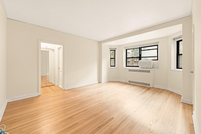 34-21 78th St Unit 1H, Jackson Heights, NY 11372 - unfurnished room featuring radiator heating unit, light wood-type flooring, and baseboards