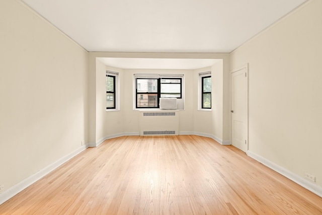 34-21 78th St Unit 1H, Jackson Heights, NY 11372 - unfurnished room with radiator heating unit, light wood-style floors, and baseboards