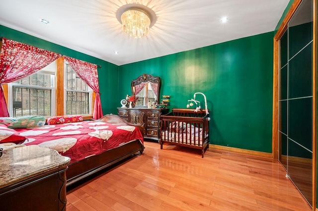 3415 91st St, East Elmhurst, NY 11369 - bedroom with a chandelier, wood finished floors, and baseboards