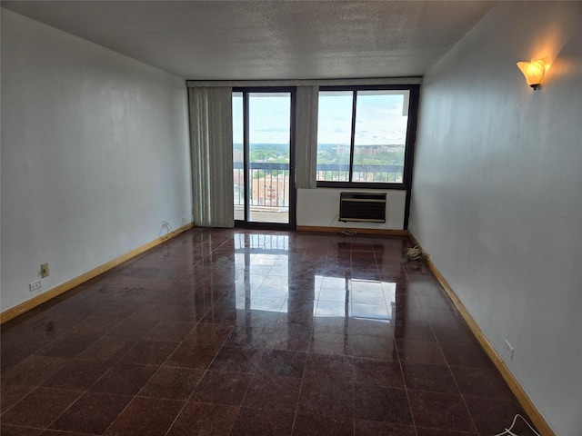 152-18 Union Tpke Unit 11J, Kew Garden Hills, NY 11367 - spare room with baseboards, granite tiled floors, a wall unit AC, and a textured ceiling