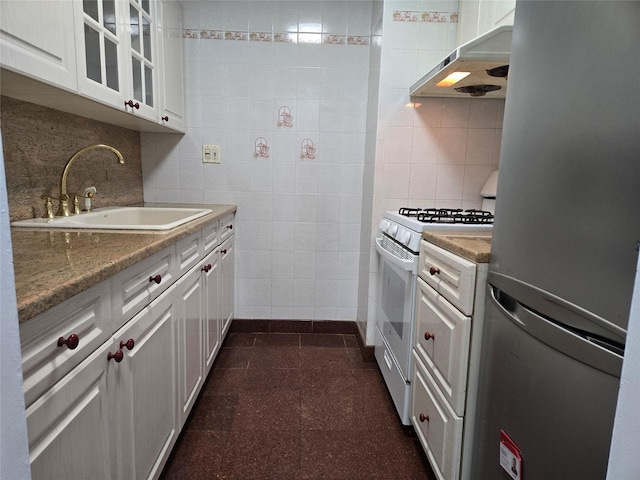 152-18 Union Tpke Unit 11J, Kew Garden Hills, NY 11367 - kitchen with freestanding refrigerator, a sink, under cabinet range hood, white gas range, and tile walls