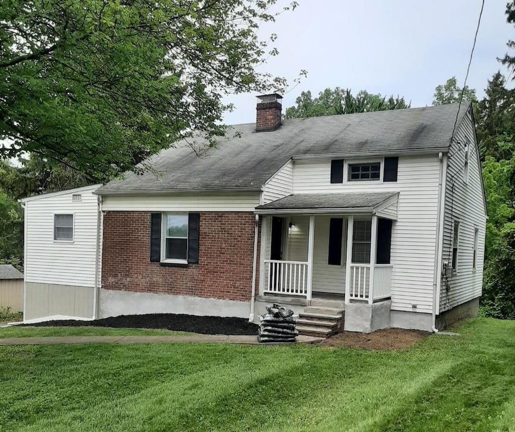 15 Spackenkill Rd, Poughkeepsie, NY 12603 - view of front of property with covered porch, a chimney, a front yard, and brick siding