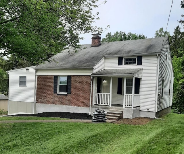 15 Spackenkill Rd, Poughkeepsie, NY 12603 - view of front of property with covered porch, a chimney, a front yard, and brick siding