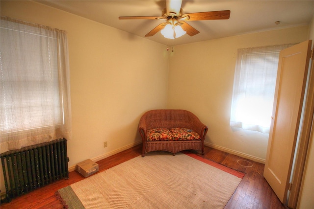 115-31 237th St, Elmont, NY 11003 - sitting room with radiator, ceiling fan, wood finished floors, and baseboards
