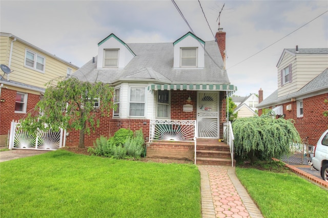 115-31 237th St, Elmont, NY 11003 - view of front of home featuring a front lawn, brick siding, and a chimney