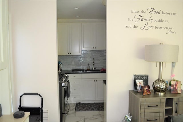 19 Maple Crest Dr, Peekskill, NY 10566 - kitchen with a sink, marble look tile flooring, stainless steel range with gas stovetop, tasteful backsplash, and white cabinetry