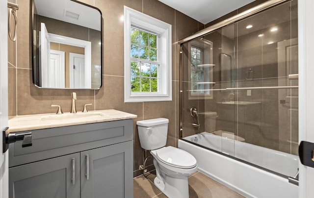 1850 Voshage St, Baldwin, NY 11510 - bathroom featuring toilet, vanity, bath / shower combo with glass door, tile walls, and tile patterned flooring