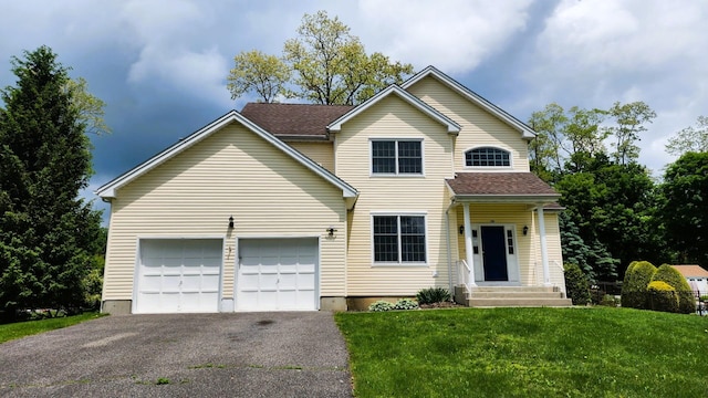 28 Hynard Pl, Baldwin Place, NY 10505 - traditional-style home featuring driveway, a front yard, an attached garage, and roof with shingles