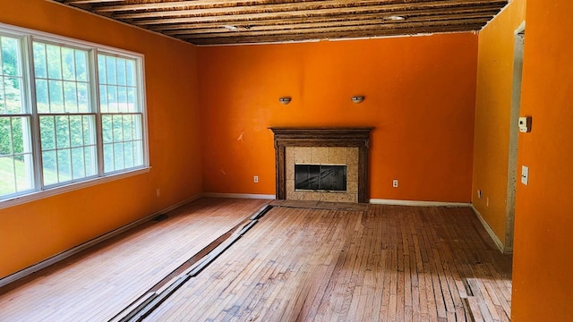 28 Hynard Pl, Baldwin Place, NY 10505 - unfurnished living room featuring healthy amount of natural light, hardwood / wood-style flooring, a tiled fireplace, and baseboards