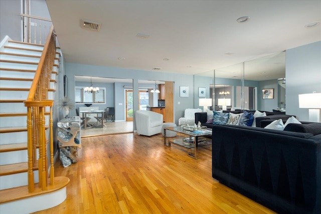 1360 Powell Ave, Merrick, NY 11566 - living room featuring a chandelier, stairs, and light wood-type flooring