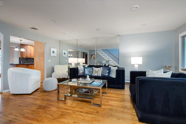 1360 Powell Ave, Merrick, NY 11566 - living room featuring light wood-type flooring, stairs, a baseboard radiator, and a chandelier