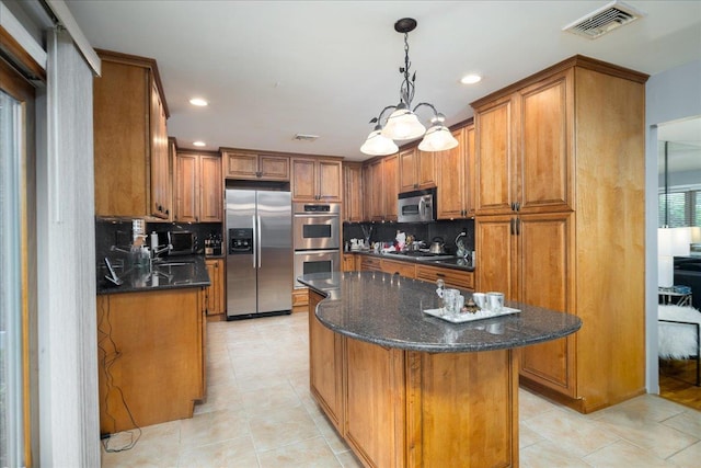 1360 Powell Ave, Merrick, NY 11566 - kitchen with appliances with stainless steel finishes, brown cabinetry, a kitchen island, light tile patterned flooring, and recessed lighting
