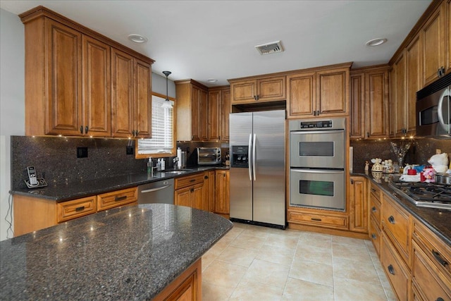 1360 Powell Ave, Merrick, NY 11566 - kitchen with stainless steel appliances, brown cabinetry, tasteful backsplash, light tile patterned flooring, and decorative light fixtures