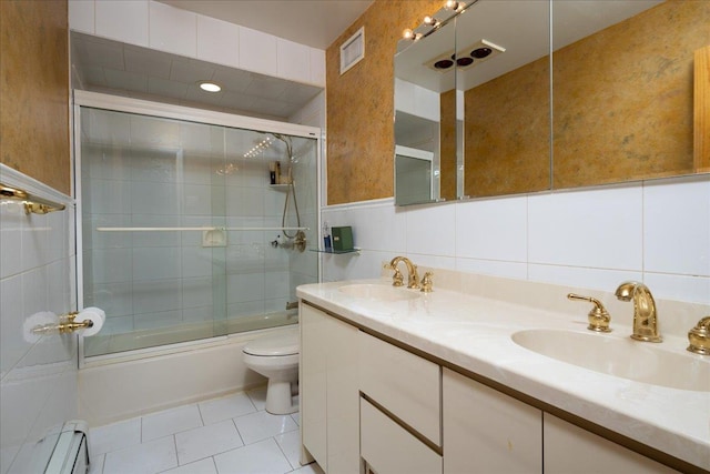 1360 Powell Ave, Merrick, NY 11566 - full bathroom featuring a baseboard heating unit, double vanity, combined bath / shower with glass door, tile patterned flooring, and tile walls