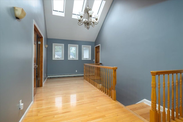 1360 Powell Ave, Merrick, NY 11566 - hall with an upstairs landing, baseboard heating, high vaulted ceiling, wood finished floors, and a chandelier