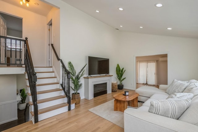 64 W Granada Ave, Lindenhurst, NY 11757 - living area featuring vaulted ceiling, a glass covered fireplace, wood finished floors, recessed lighting, and a wall mounted air conditioner