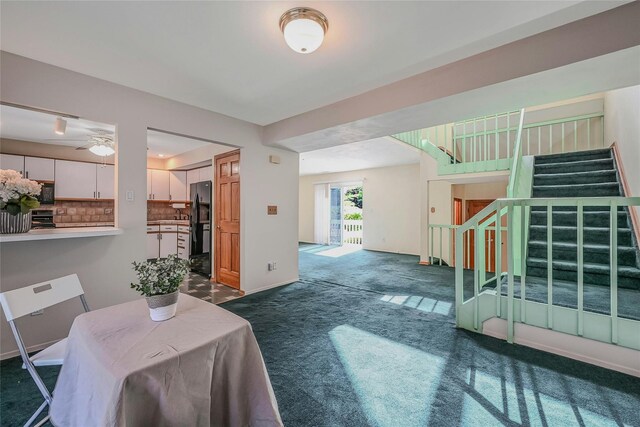 35 Gibbs Rd Unit 39, Coram, NY 11727 - living room with stairs, dark colored carpet, and a ceiling fan