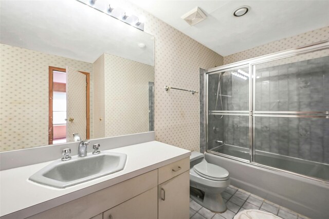 35 Gibbs Rd Unit 39, Coram, NY 11727 - full bath with toilet, tile patterned flooring, vanity, wallpapered walls, and shower / bath combination with glass door