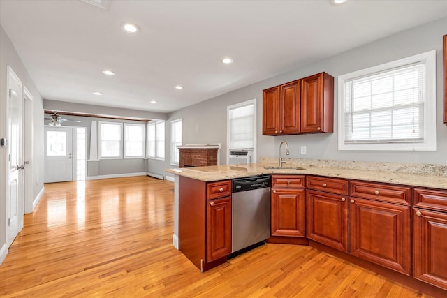 44 Wyoming Ave, Long Beach, NY 11561 - kitchen with stainless steel dishwasher, a sink, light wood finished floors, a peninsula, and light stone countertops