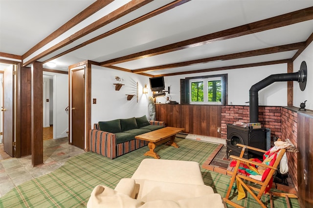 16 Fairway Dr, Eldred, NY 12743 - living room featuring a wood stove, beam ceiling, wood walls, and a wainscoted wall