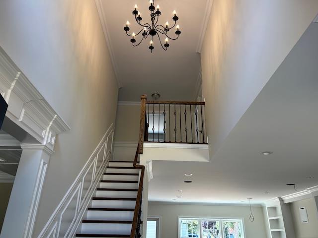 51 Michigan Ave, Massapequa, NY 11758 - staircase with a towering ceiling, ornamental molding, and a chandelier