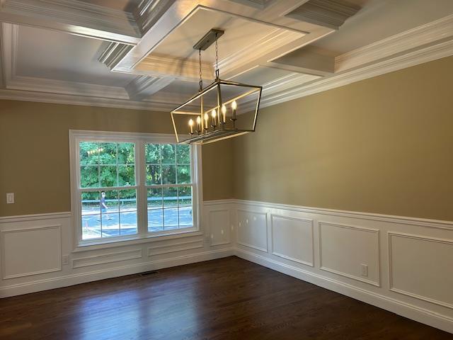 51 Michigan Ave, Massapequa, NY 11758 - empty room with a chandelier, crown molding, coffered ceiling, wainscoting, and dark wood-type flooring