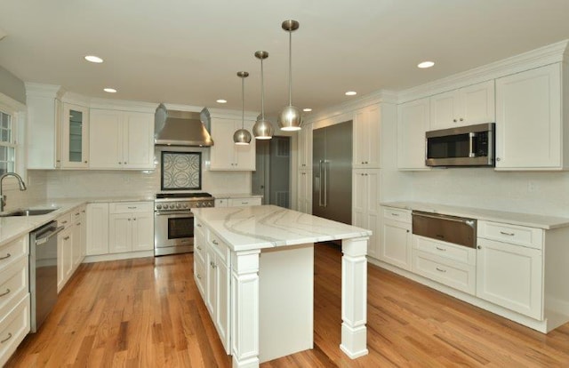 51 Michigan Ave, Massapequa, NY 11758 - kitchen featuring wall chimney exhaust hood, appliances with stainless steel finishes, a warming drawer, a center island, and white cabinetry